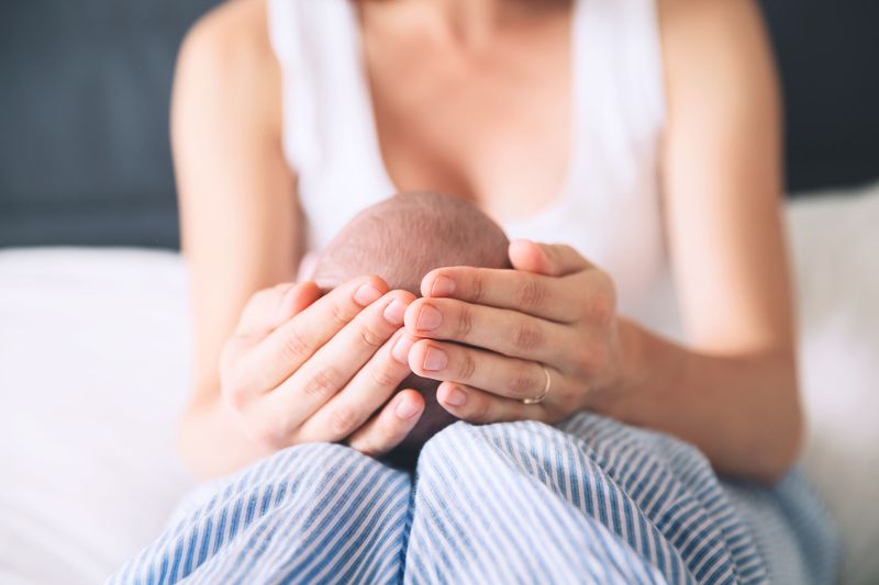 mother holding baby, baby small head